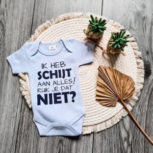 Licht blauwe romper bedrukt met de tekst: Schijt aan alles