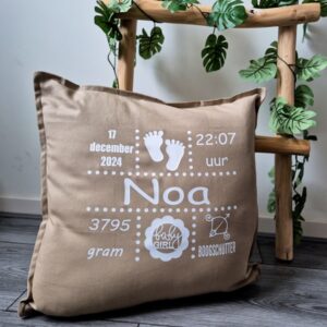 Beige kussen bedrukt met naam en geboortegegevens.