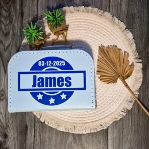 Licht blauw logeerkoffertje met een stempel waarin de naam en geboortedatum staat.