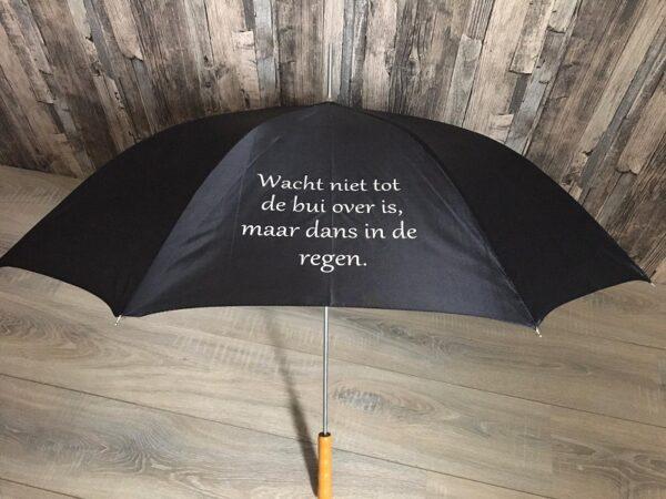 Zwarte paraplu bedrukt met de tekst: Dans in de regen