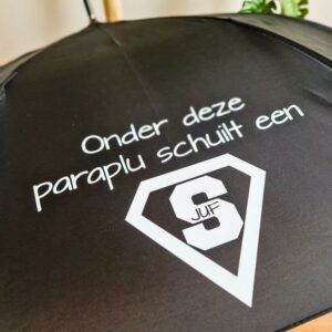 Zwarte paraplu bedrukt de tekst: onder deze paraplu schuilt een superjuf / supermeester.