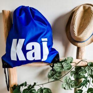 Blauwe rugtas met touwtjes bedrukt met naam