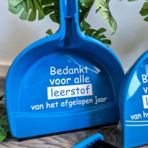Blauwe handveger en blik bestickerd met de tekst: Bedankt voor alle leerstof van het afgelopen jaar.