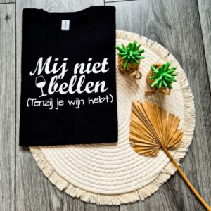Zwart t-shirt bedrukt met de tekst: Mij niet bellen (tenzij je wijn hebt). Het shirt is extra vrolijk dankzij het afgebeelde glas wijn.