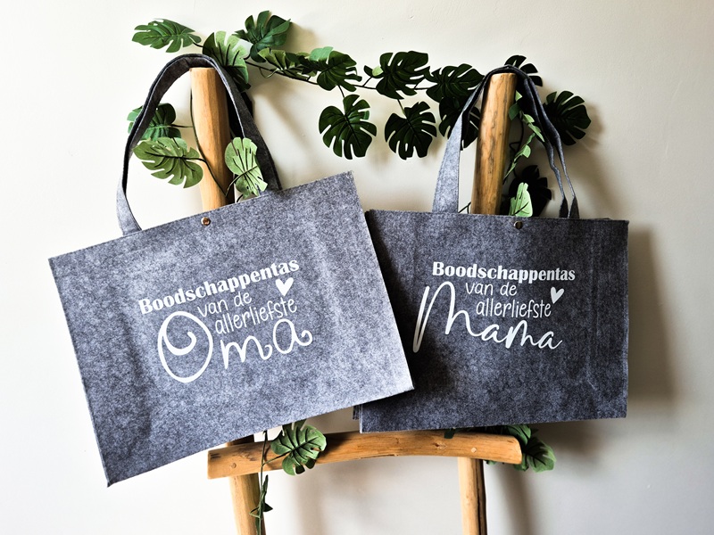 Grijze vilten tassen bedrukt met de tekst: Boodschappentas van de allerliefste oma en mama.