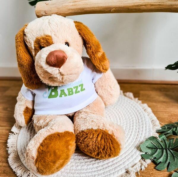 Knuffel hond met een bedrukt t-shirt met logo van bedrijf.