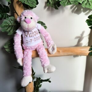 Roze knuffelaap met naam bedrukt op t-shirt.