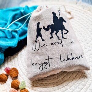 Beige pepernotenzakje gemaakt van linnen. Het zakje heeft een afmeting van 15x20 cm en is bedrukt met de tekst: wie zoet is krijgt lekkers. De Sint en zijn piet afgebeeld.