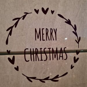 Raamsticker met de tekst Merry Christmas en omringt door takjes en hartjes