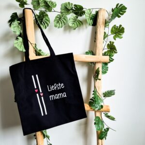 Zwarte katoenen tas met lange hengsels. Bedrukt met de tekst Liefste mama en afgewerkt met 2 strepen en hartjes.