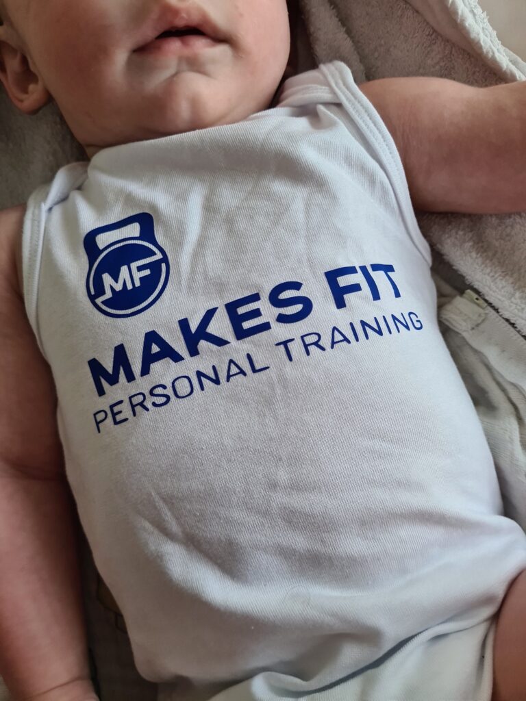 Baby met romper aan. Romper is bedrukt met logo van bedrijf.