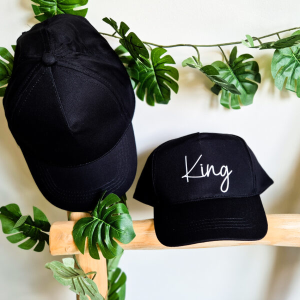 Zwarte, unisex pet bedrukt met de tekst 'King'.