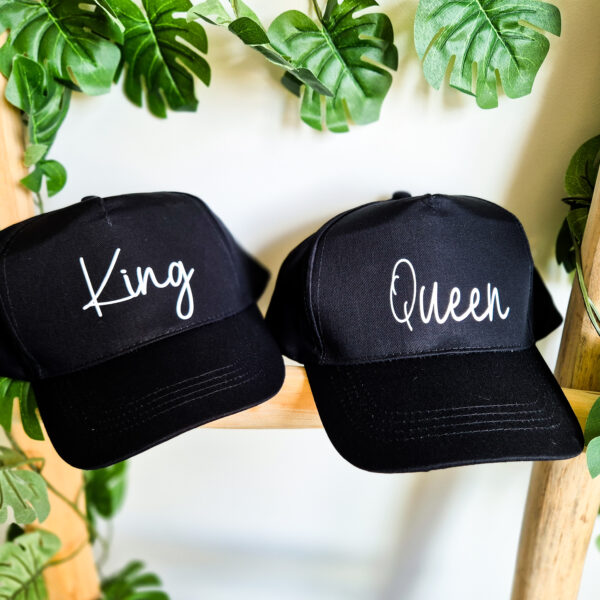 Zwarte petten bedrukt met de teksten 'King' en 'Queen'