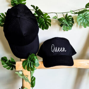 Zwarte, unisex pet bedrukt met de tekst 'Queen'.
