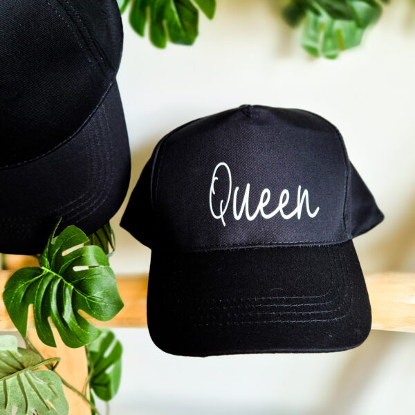 Detailfoto van zwarte, unisex pet bedrukt met de tekst 'Queen'.