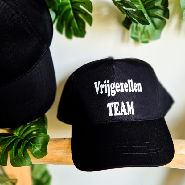 Detailfoto van zwarte, unisex pet bedrukt met de tekst 'Vrijgezellen team'.