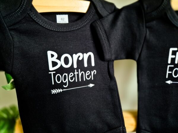 Zwarte romper bedrukt met de tekst Born Together. Deze romper is een deel van een set.