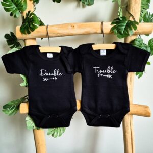 Zwarte rompers bedrukt met de teksten Double Trouble.