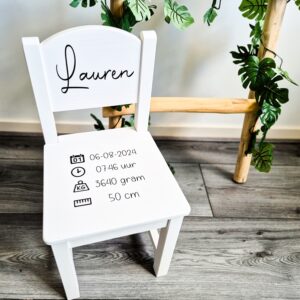 Witte houten kinderstoel met naam en geboortegegevens.