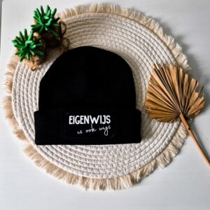 Zwarte unisex muts bedrukt met de tekst: Eigenwijs is ook wijs.