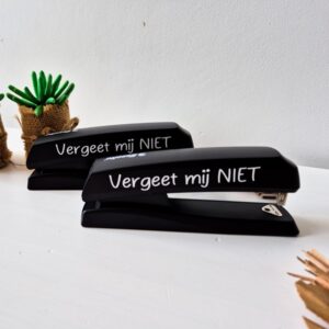 Zwarte nietmachine bestickerd met de tekst: Vergeet mij niet.