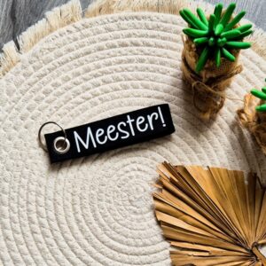 Zwarte vilten sleutelhanger bedrukt met meester!