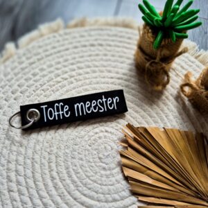 Zwarte vilten sleutelhanger bedrukt met toffe meester