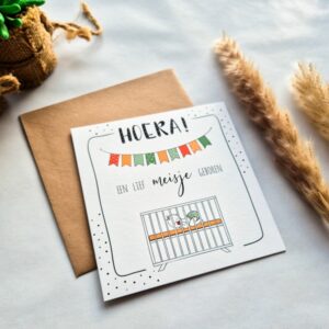 Een felicitatiekaart voor de geboorte met de tekst 'Hoera een lief meisje geboren'.