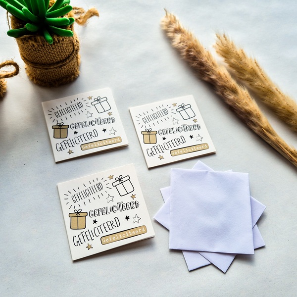 Drie dubbelzijdige verjaardagskaartjes met de tekst Gefeliciteerd. Geschreven in verschillende lettertype en afgemaakt met cadeutjes en sterretjes.
