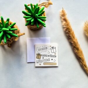 Een dubbelzijdige verjaardagskaartje met de tekst Gefeliciteerd. Geschreven in verschillende lettertype en afgemaakt met cadeutjes en sterretjes.