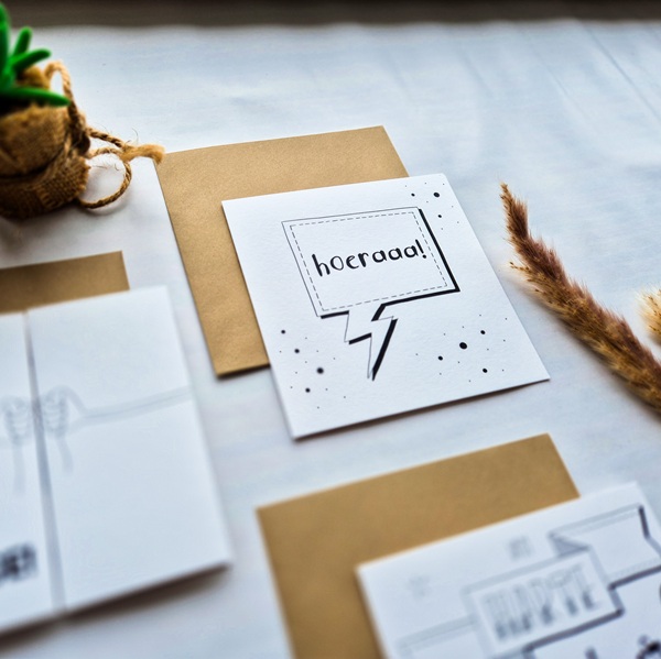 Een dubbelzijdige verjaardagskaart met de tekst Hoera.